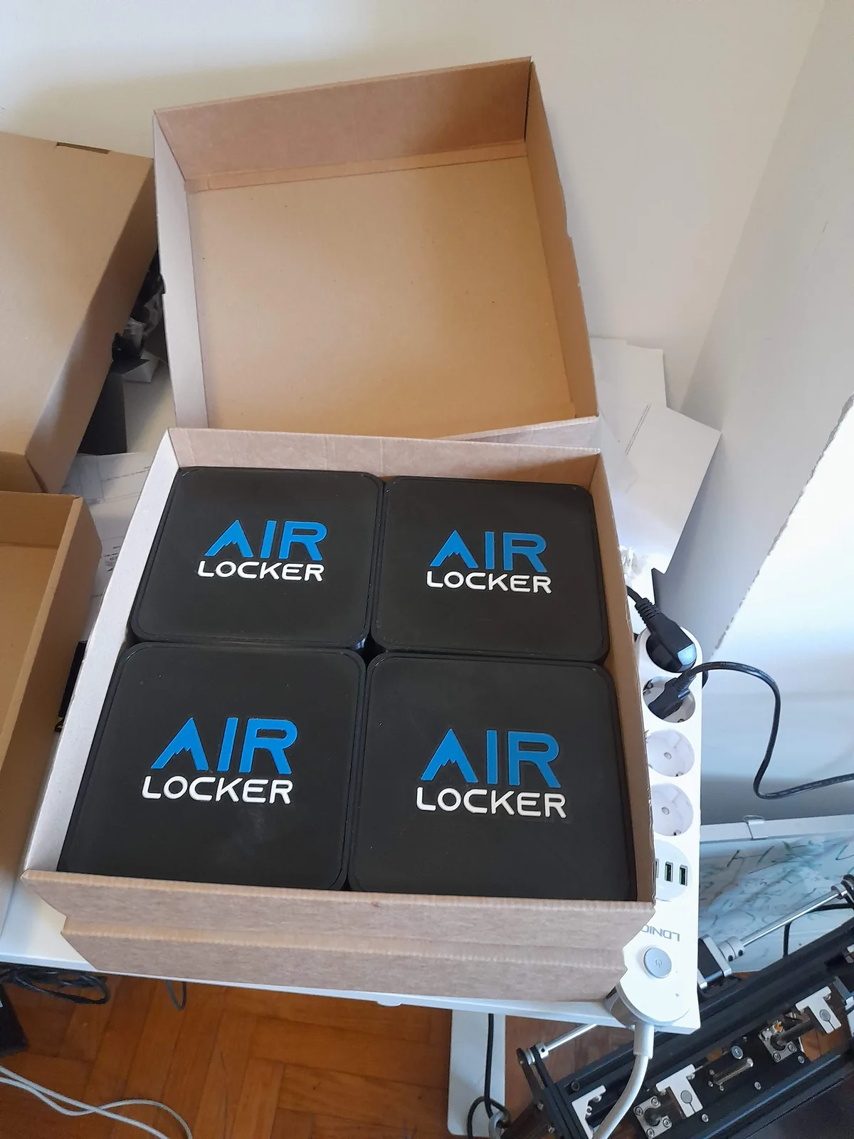 Four finished AIR LOCKER units lined up on a bench ready for packing