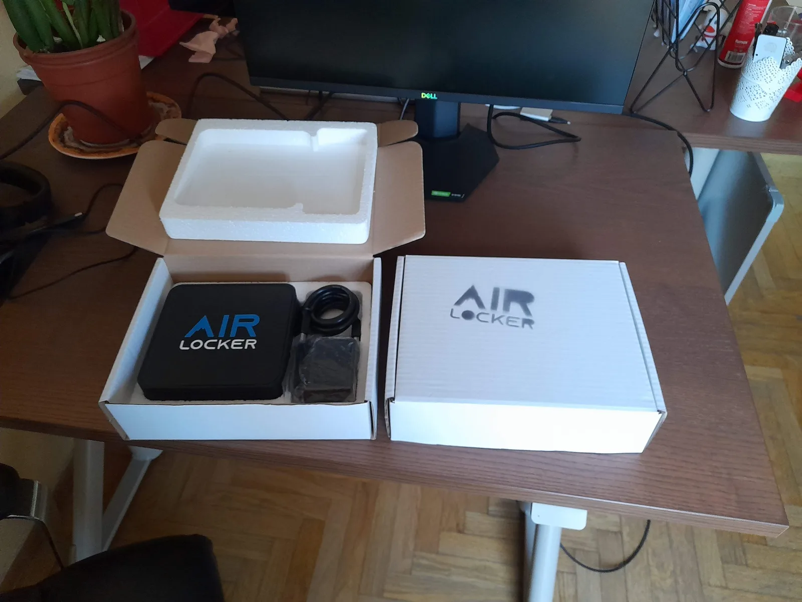 An AIR LOCKER unit in a retail box with a moulded foam insert holding the unit, power supply and cable