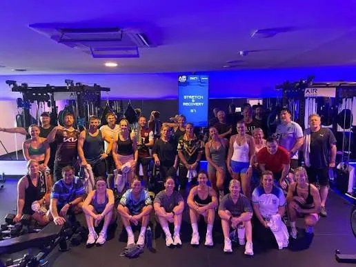 A large AirLocker class filling a studio in front of a wall-mounted screen at the end of a session